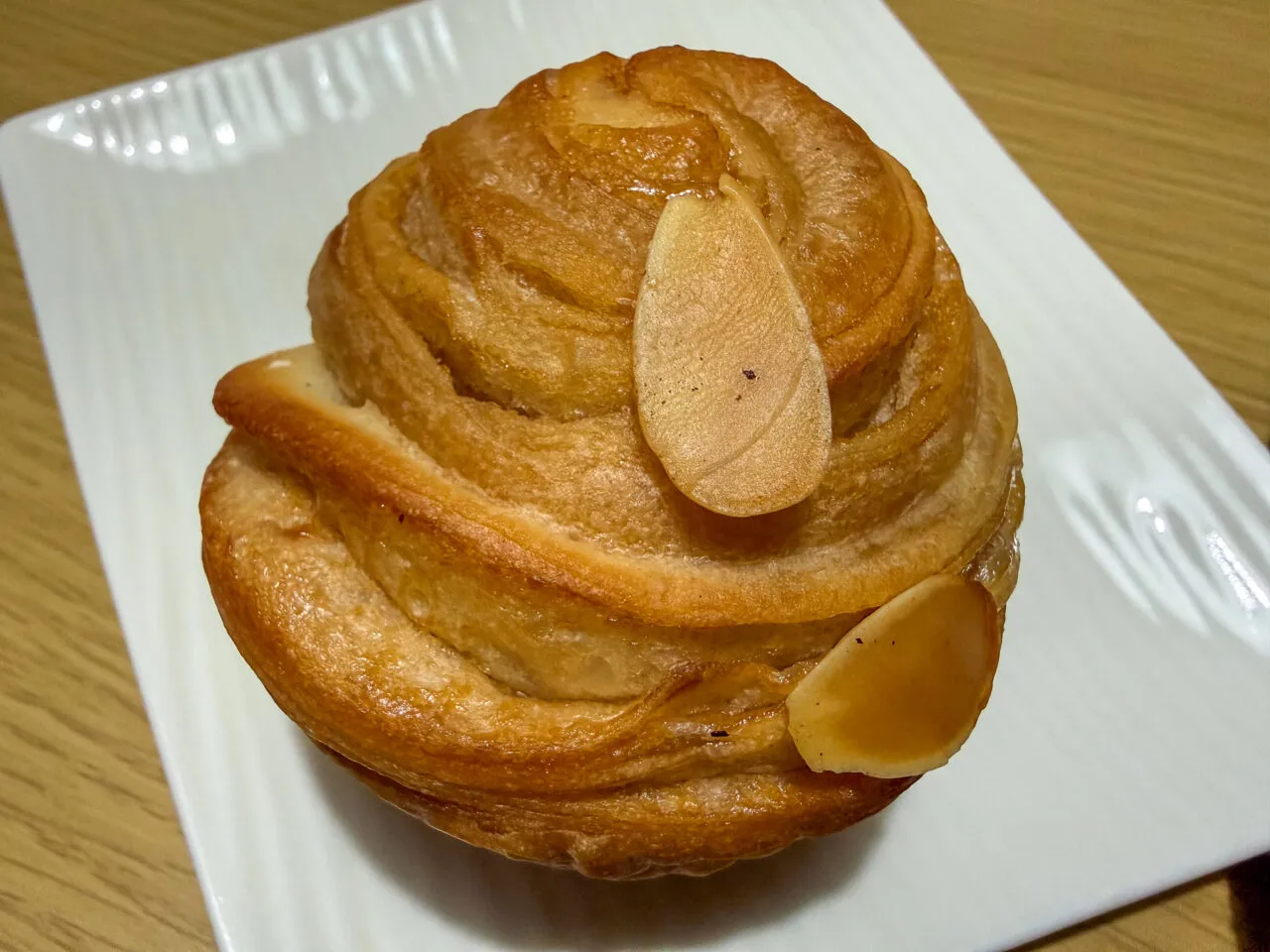 PAIN MIZA の看板クロワッサン (皿に 1 個・皮のパリッとした層)